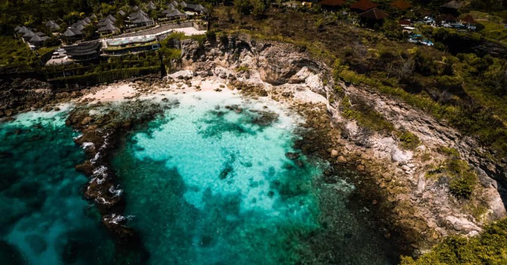 Por qué viajar a Indonesia: cala de aguas turquesas y acantilados en una isla tropical