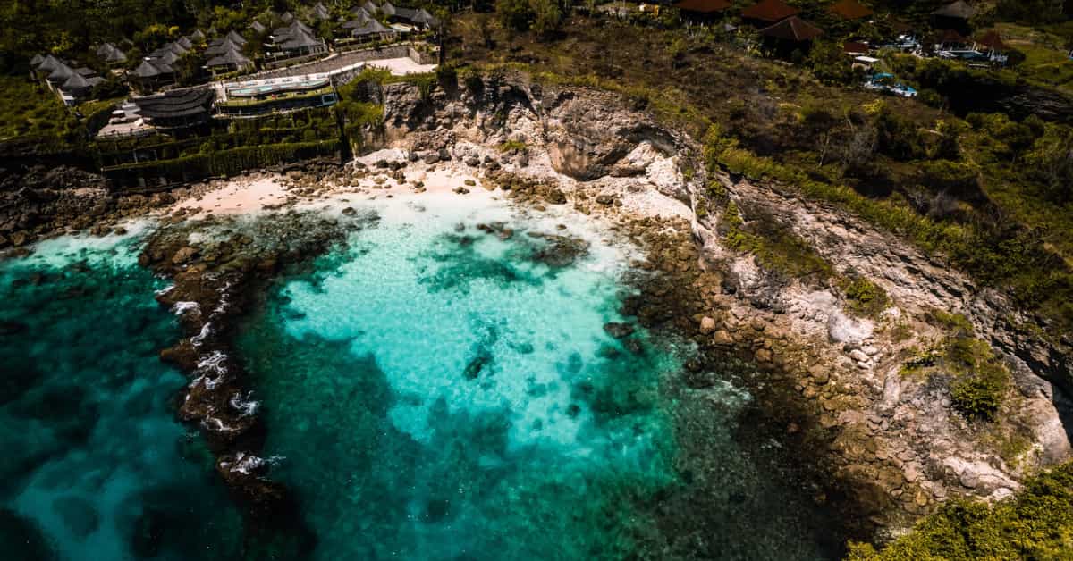 Por qué viajar a Indonesia: cala de aguas turquesas y acantilados en una isla tropical